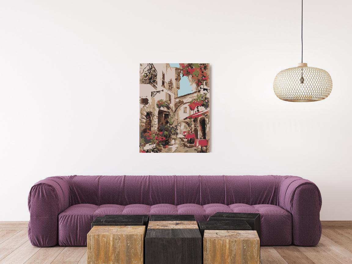 a living room with a purple couch and a painting on the wall