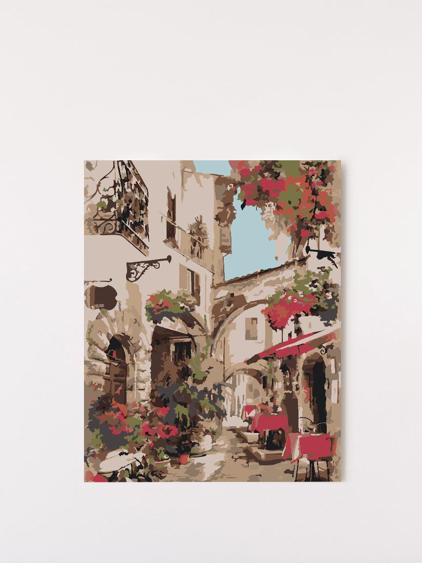 a painting of a street with flowers and buildings